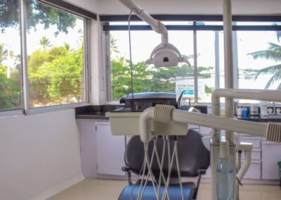 Dentist Cartagena's Office - Modern dental chair in an office with palm trees and beach outside the window