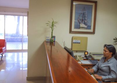 Dentist Cartagena's Office - Wooden-top front desk and waiting room in the background